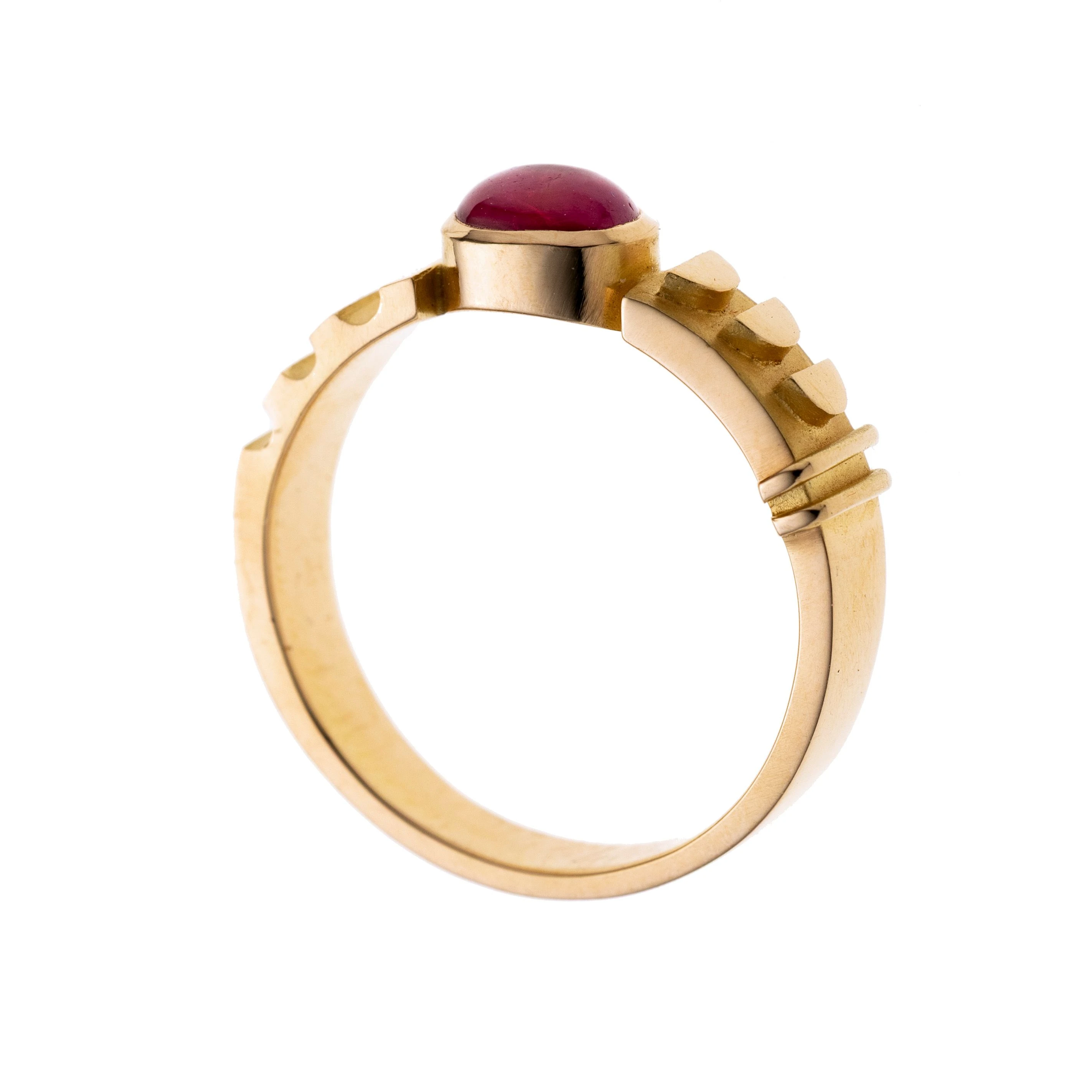 Plastisch gearbeitete Ringschultern mit Streifen- und Halbkreiselementen, die ein 0.73 ct. Rubin-Cabochon in Zarge flankieren.