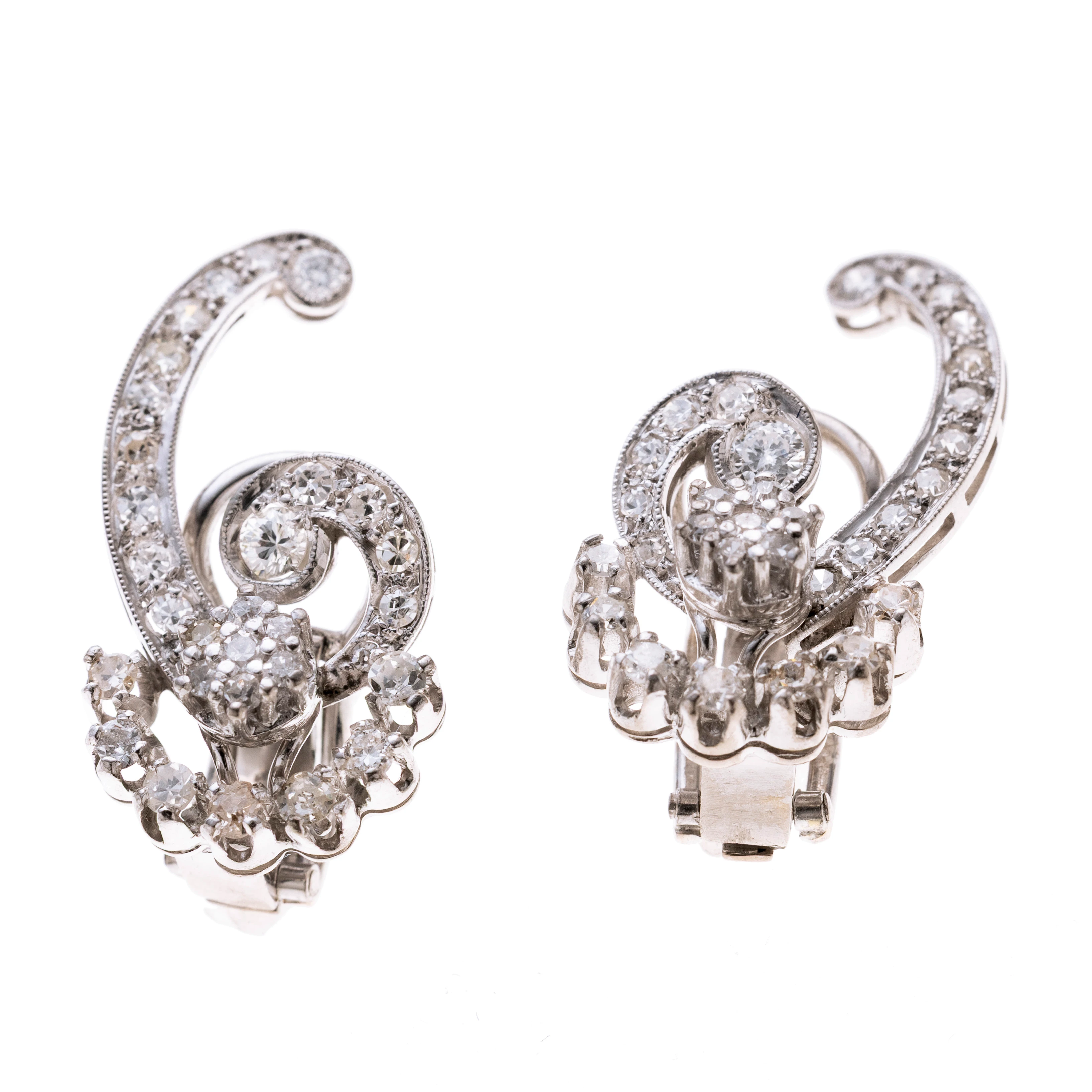 Geschweifte, geschwungene spiralförmige Form besetzt mit insgesamt 58 Achtkantdiamanten und vier Brillanten. Je Ohrring insgesamt ca. 0.57ct. Clips aus 585er Weißgold
