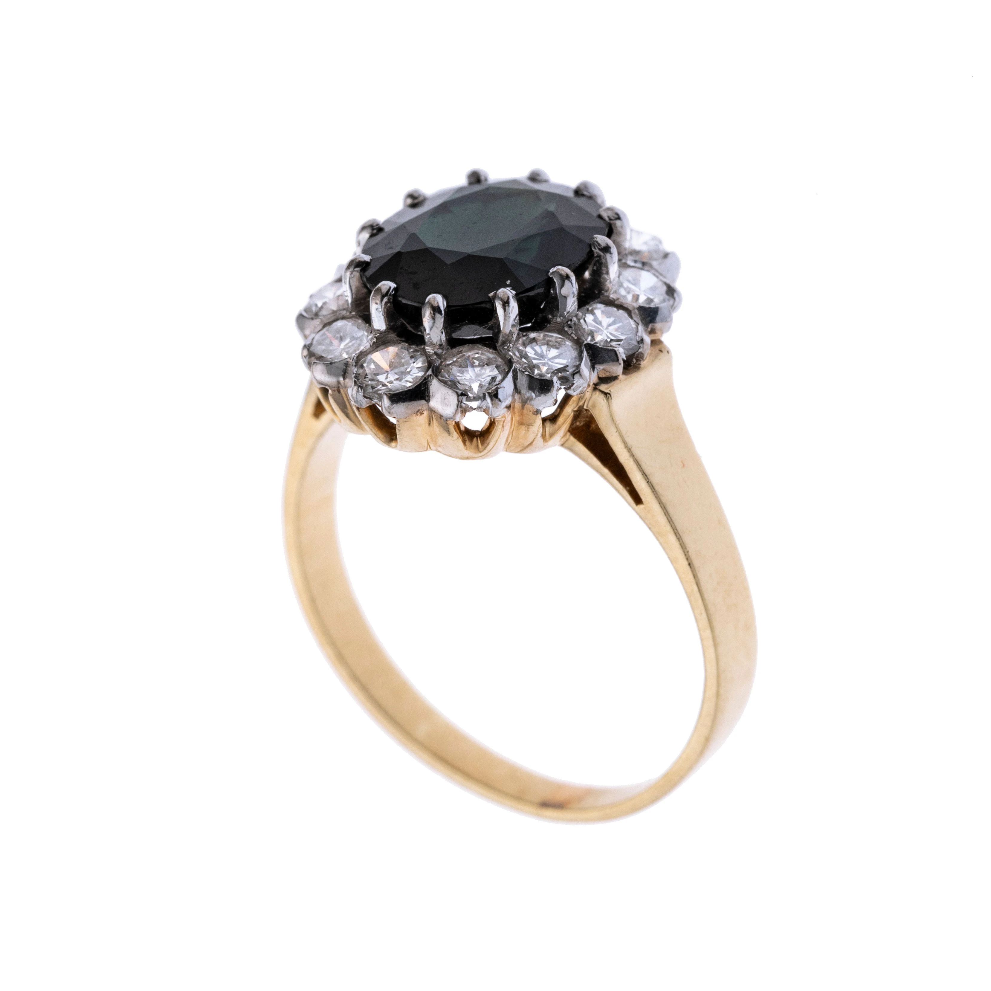 Ein Daisy-Ring mit einem ovalen Saphir, der von 12 Brillanten umgeben wird.