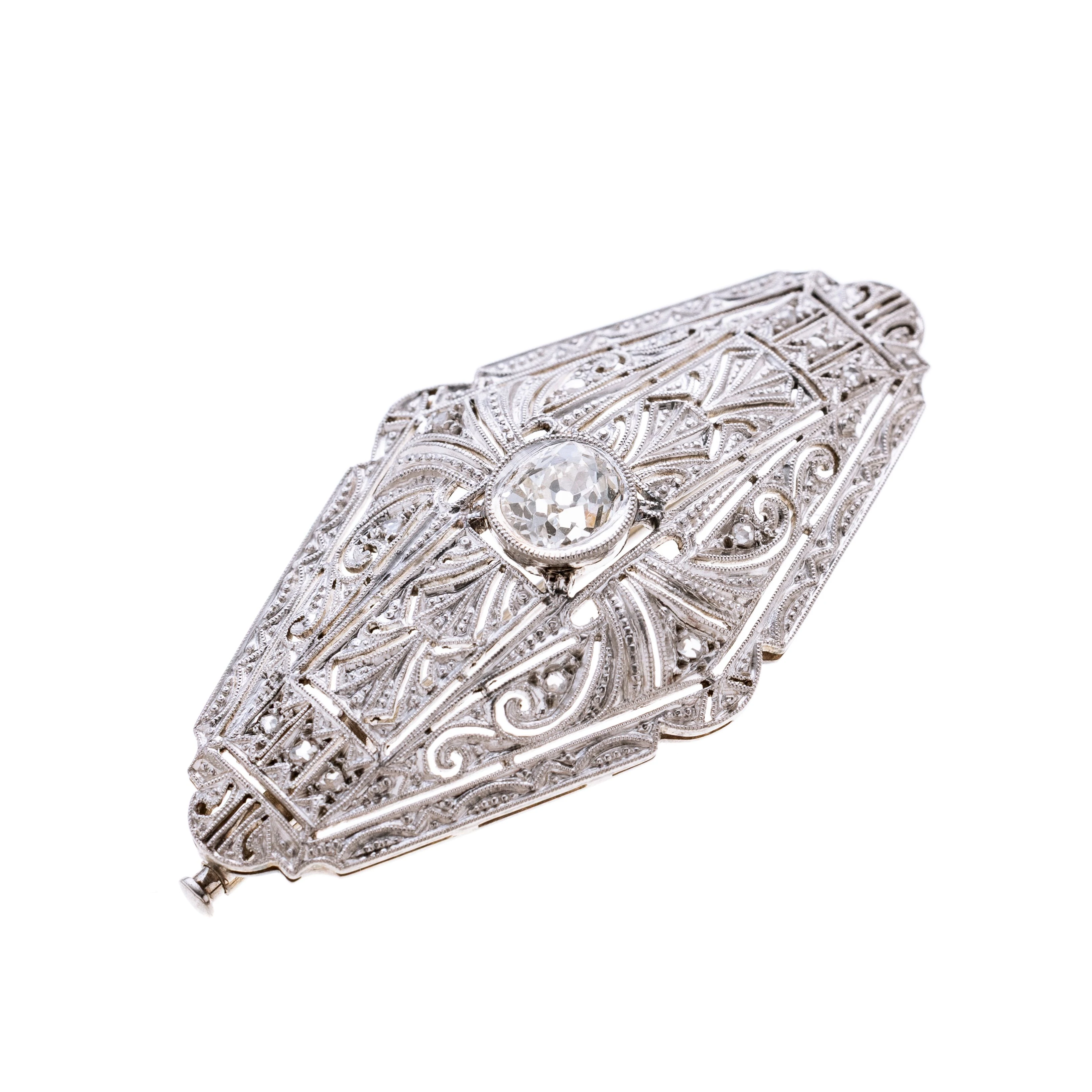 Navetteförmig , filigran gearbeitet, besetzt mit insgesamt zwölf Diamantrosen je ca. 0.005 ct und mittig in Zarge ein ca. 0.65 ct. Altschliffdiamant. Oberfläche wurde platiniert.