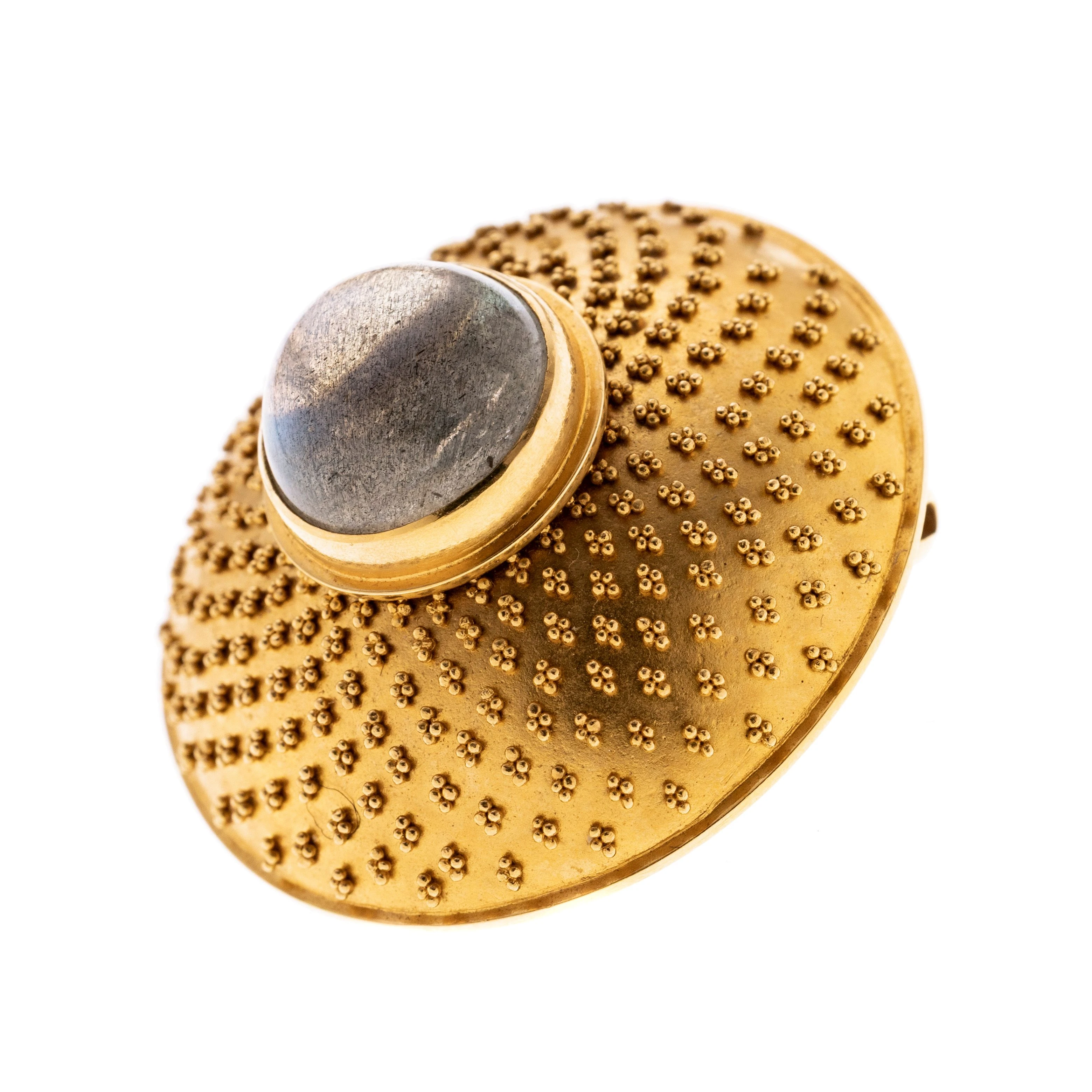 Konvex, rund mit 900er Gold Granulation und mittig einem erhöhten Labradorit-Cabochon in Zargenfassung. Signiert mit HV für Hildegard (Hilde) Vollers. Seltenheit, denn nur wenige Stücke sind von Ihr erhalten bzw. bekannt. Vgl. Chr. Weber, Schmuck der 20er und 30er Jahre, S. 335.