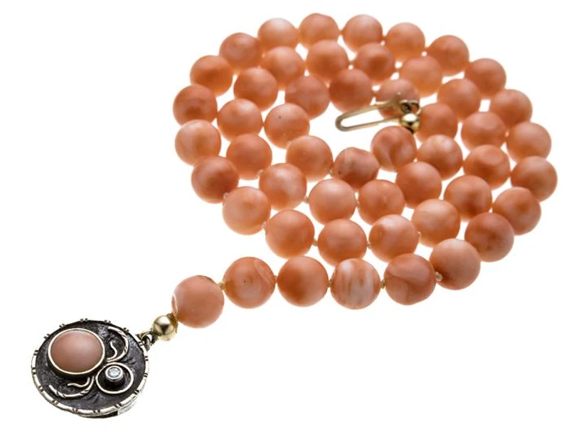 Korallenkette mit verzierten Spinnenmotiv und Diamanten als Verschluss.