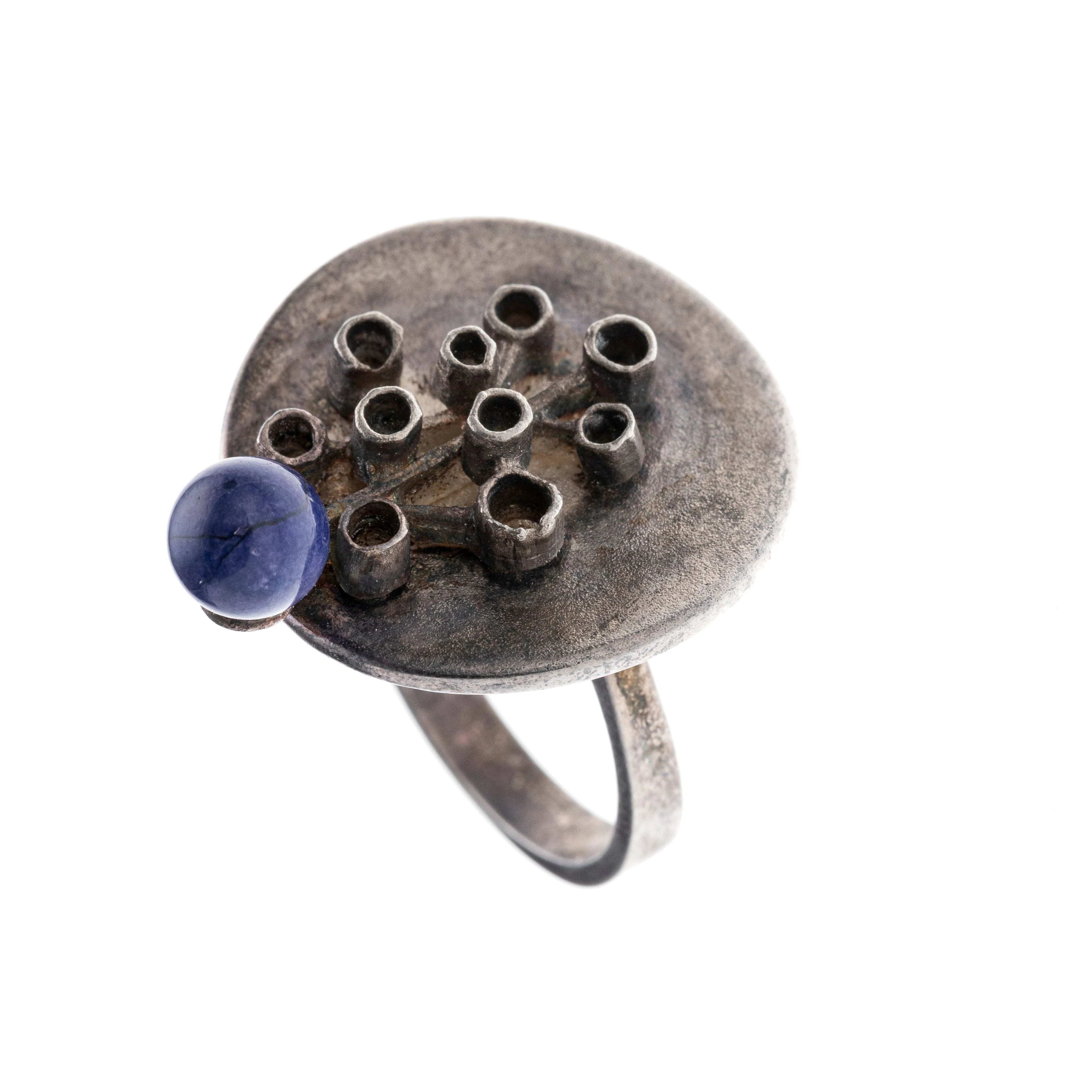 Ein Ring mit rundem Ringkopf, abstrakten Zargenverzierungen und einer dunkelblauen Achatperle. Autorenschmuck.