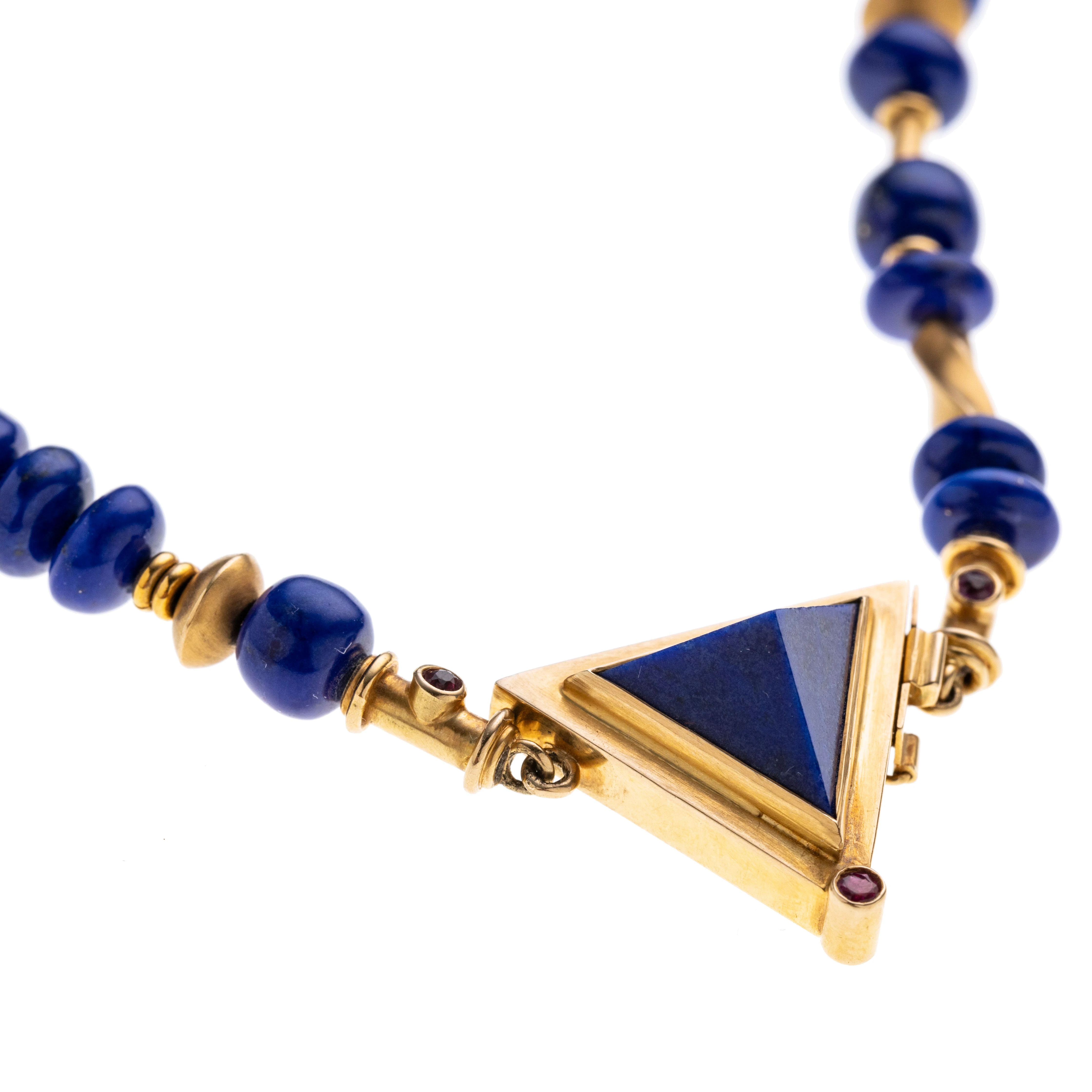 Lapislazulikette mit Geldgoldelementen und einem dreieckigen Verschluss, der drei Rubine (je ca. 0.03 ct.) fasst. Signiert.