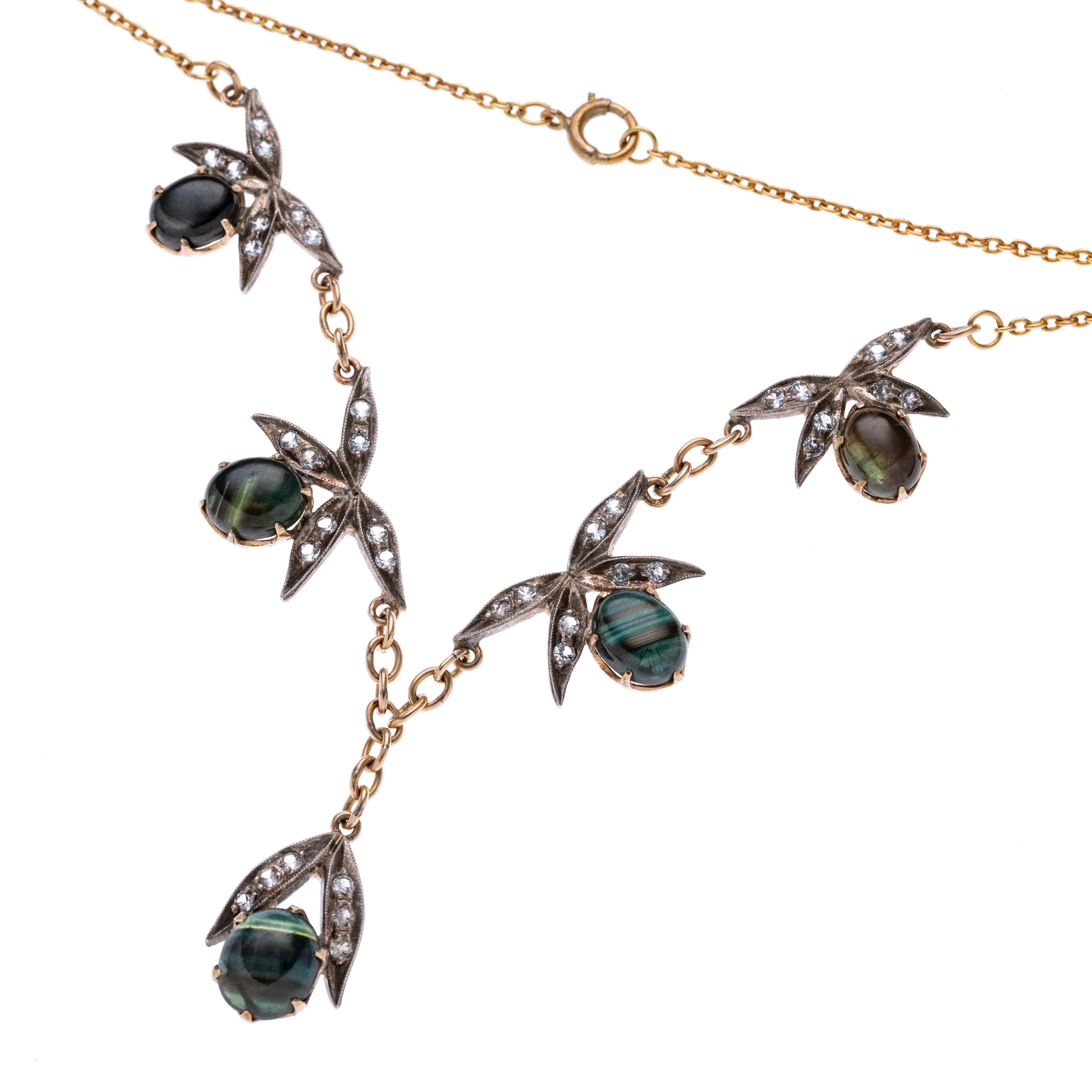 Fünf Blumen­elemente be­setzt mit Diamantenimitationen und je einem Falkenauge