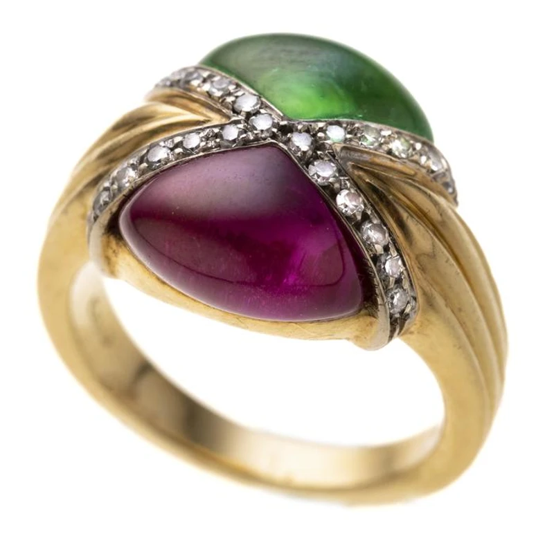 Ein grüner und ein pinker Triangel-Cabochon sich gegenüber liegend, umrahmt von Achtkantdiamanten. Gerillte Ringschiene.