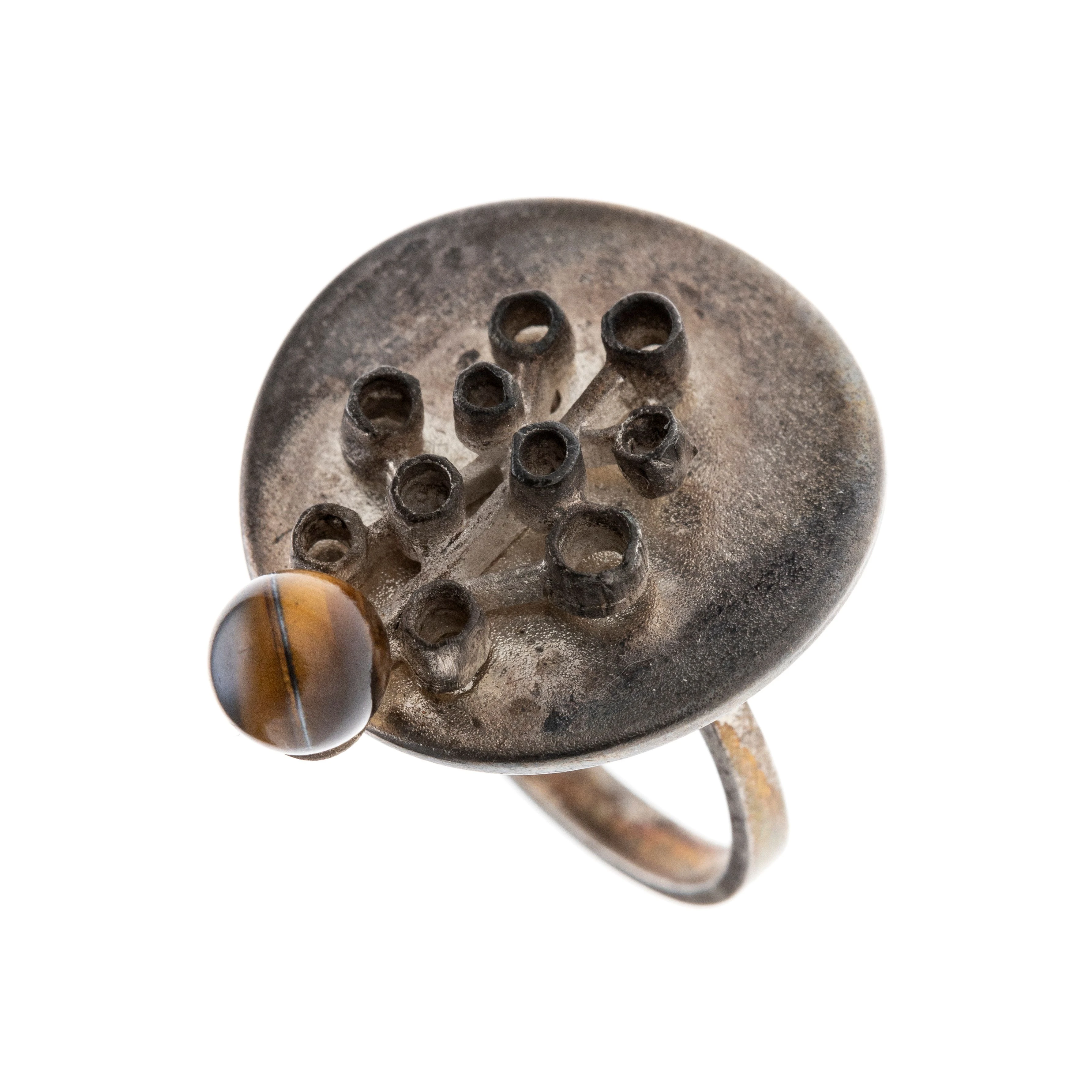 Ein Ring mit rundem Ringkopf, abstrakten Zargenverzierungen und einer Tigeraugenkugel. Autorenschmuck.