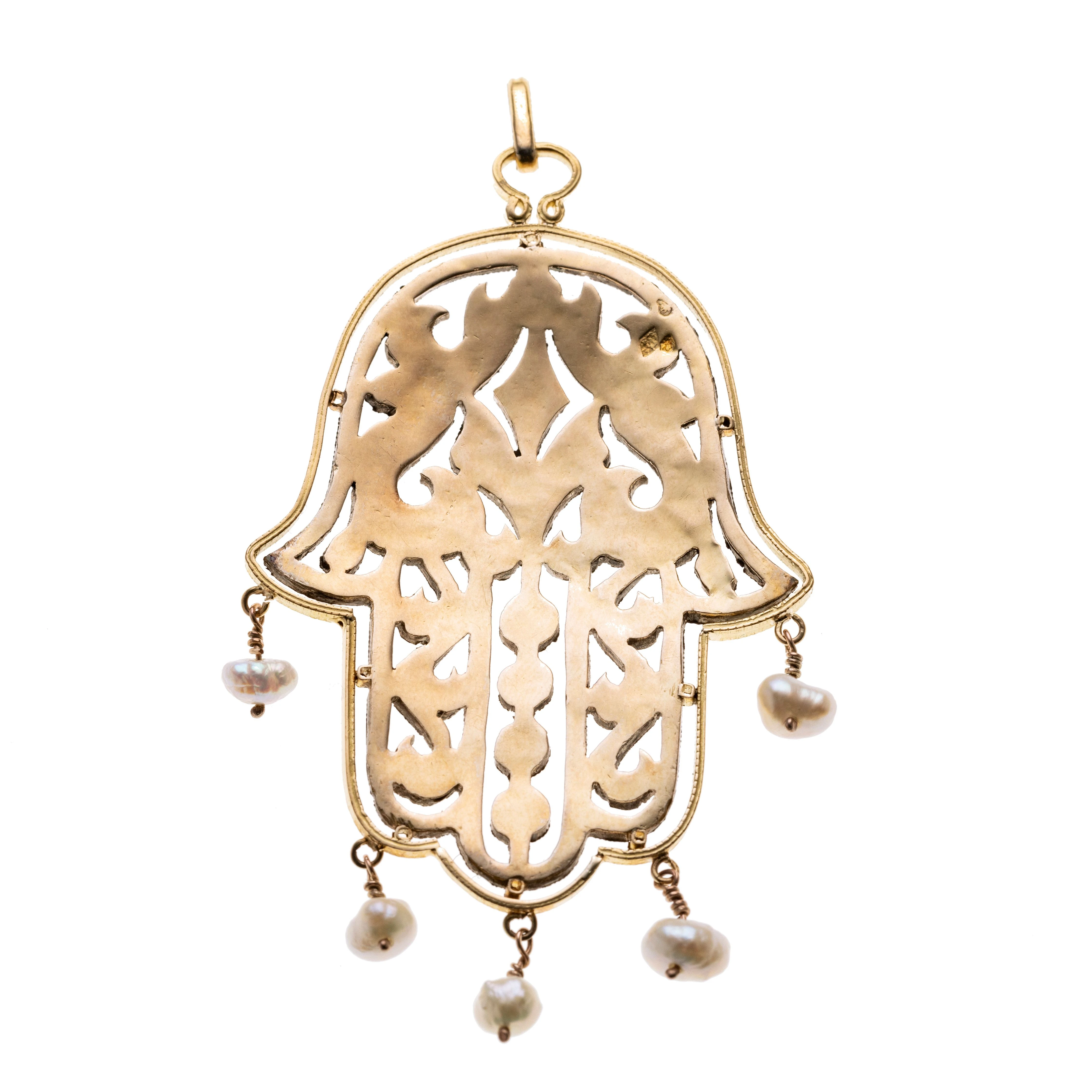 . Die Hand der Fatima, besetzt mit in Silber gefassten Diamanten und mit fünf abgehängten Perlen. Länge mit Öse 75 mm, Breite 32 mm.