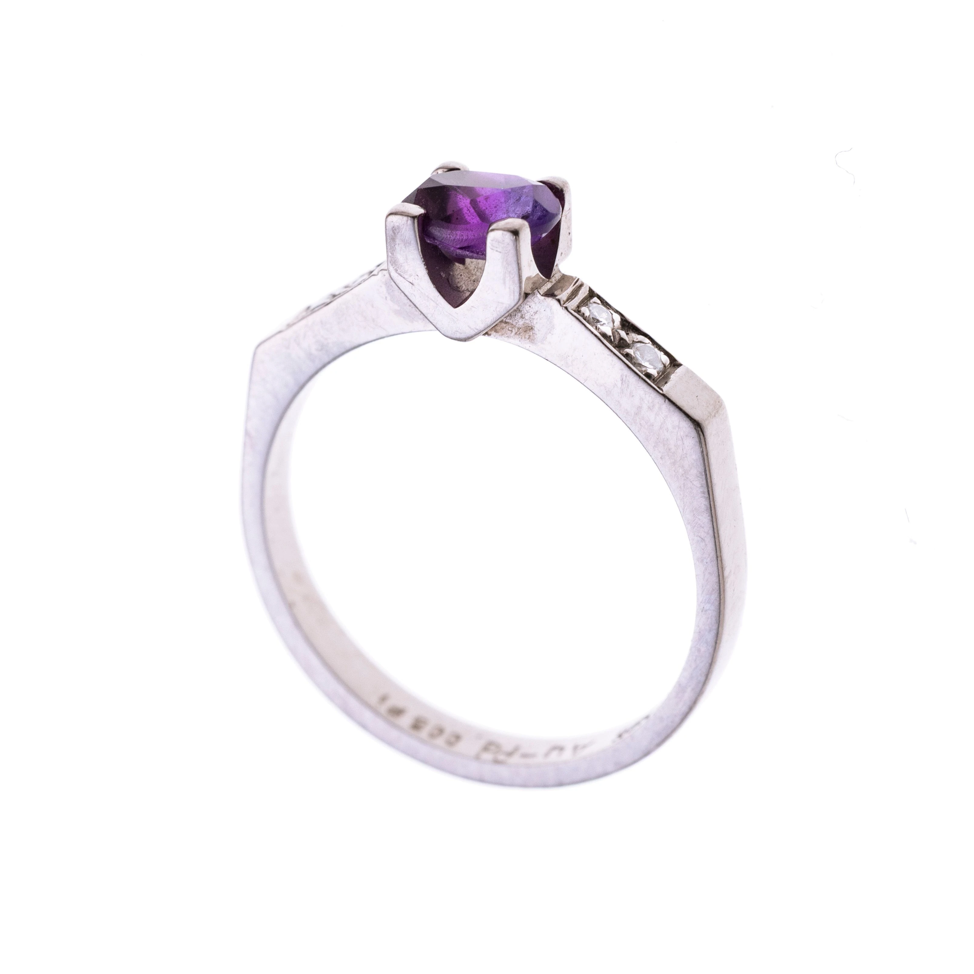 Ein ovaler Amethyst in Krappen gefasst flankiert von insgesamt vier Diamanten je ca. 0.01 ct