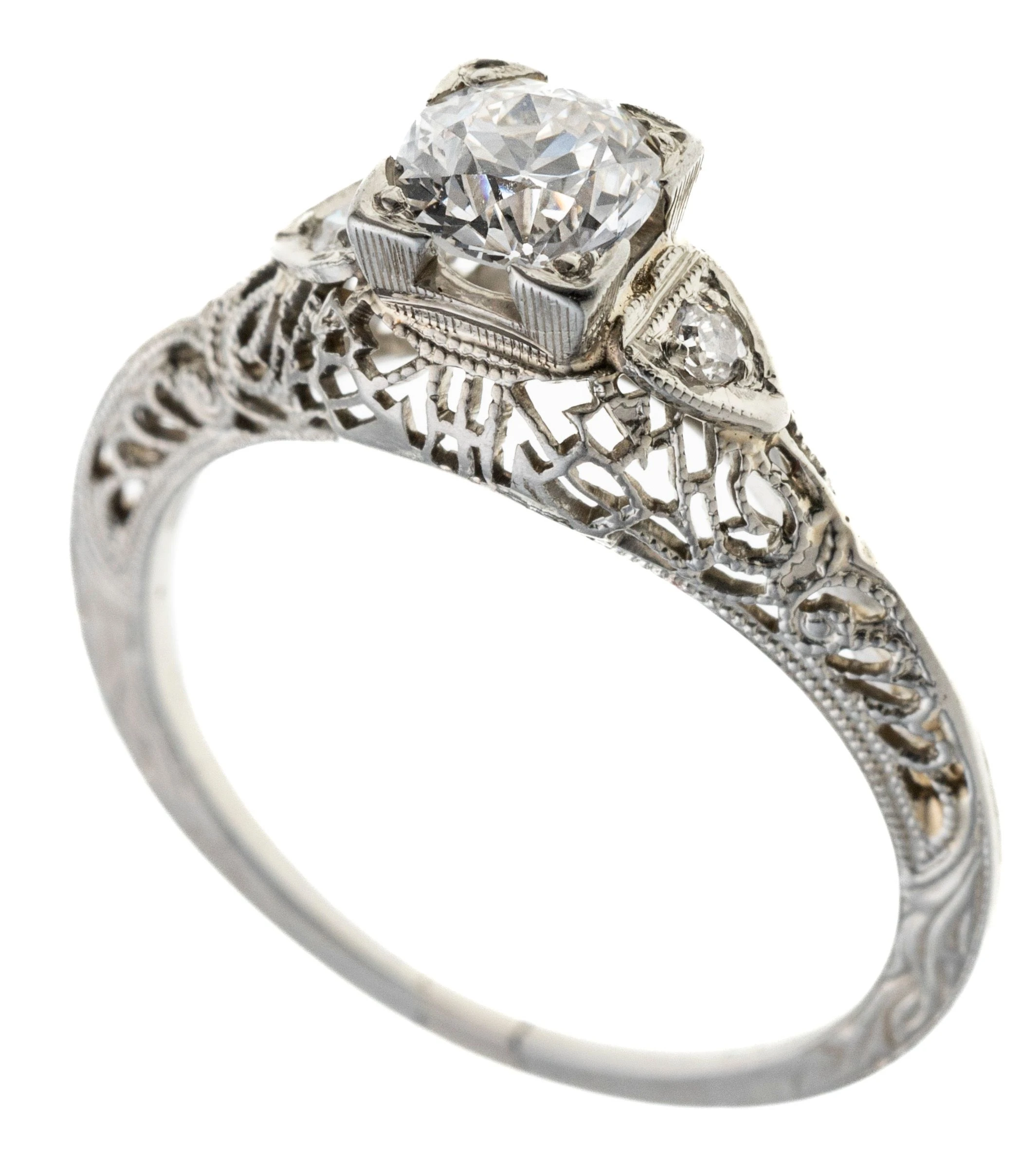 Eine filigran à jour gearbeitete Ringschiene mit floralen Gravuren und Millégriffeverzierung. Besetzt mit einem Altschliff diamanten in quadratischer Fassung, der von insgesamt zwei Diamanten, zusammen 0.04 ct., flankiert wird.