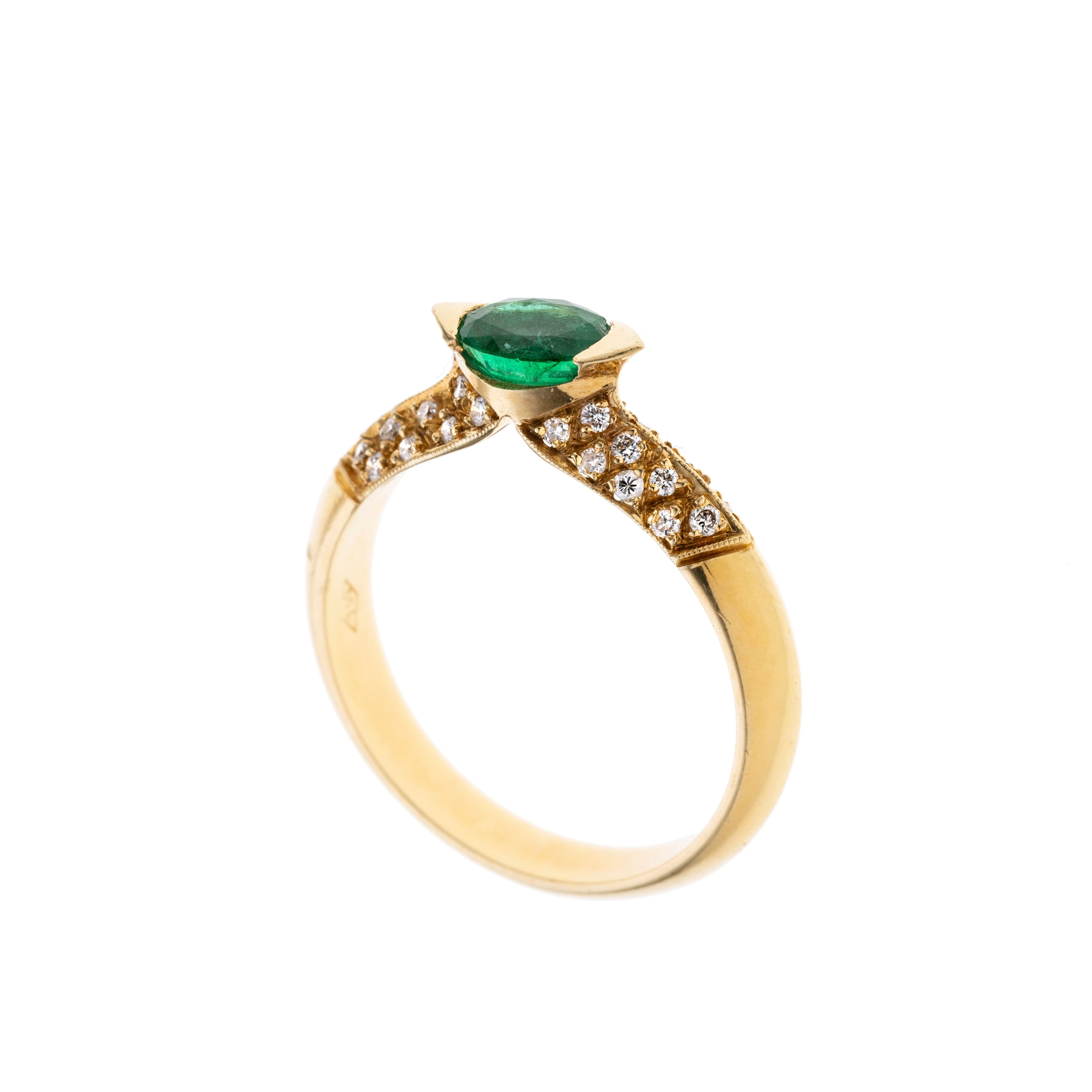 Ein erhöt gefasster ovaler Smaragd in zwei dreieckigen Krappen. Die Ringschultern sind pavé gefasst mit insgesamt 32 Brillanten je ca. 0.01 ct.