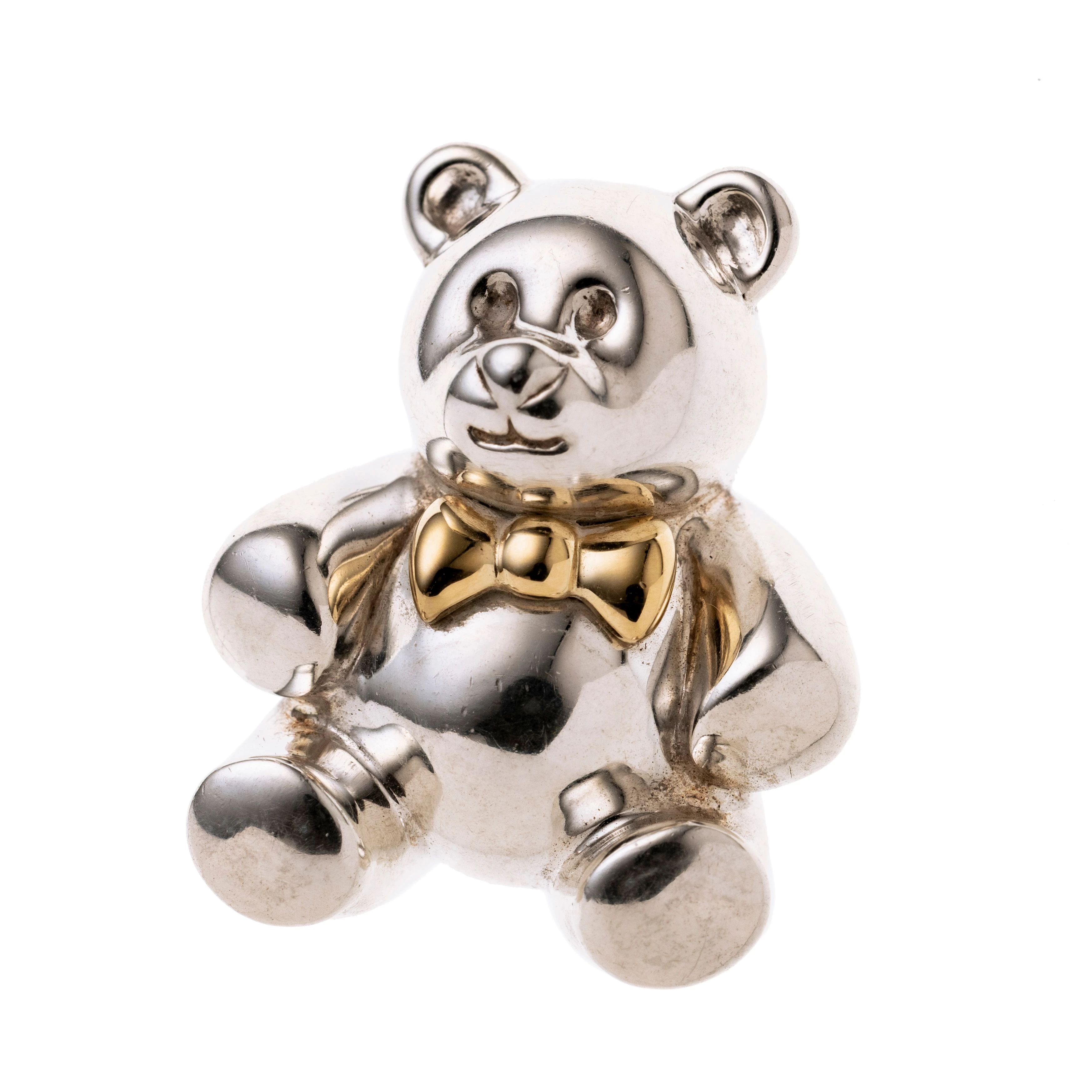 Ein Teddybär mit goldener Schleife. Mit Stofftäschen.