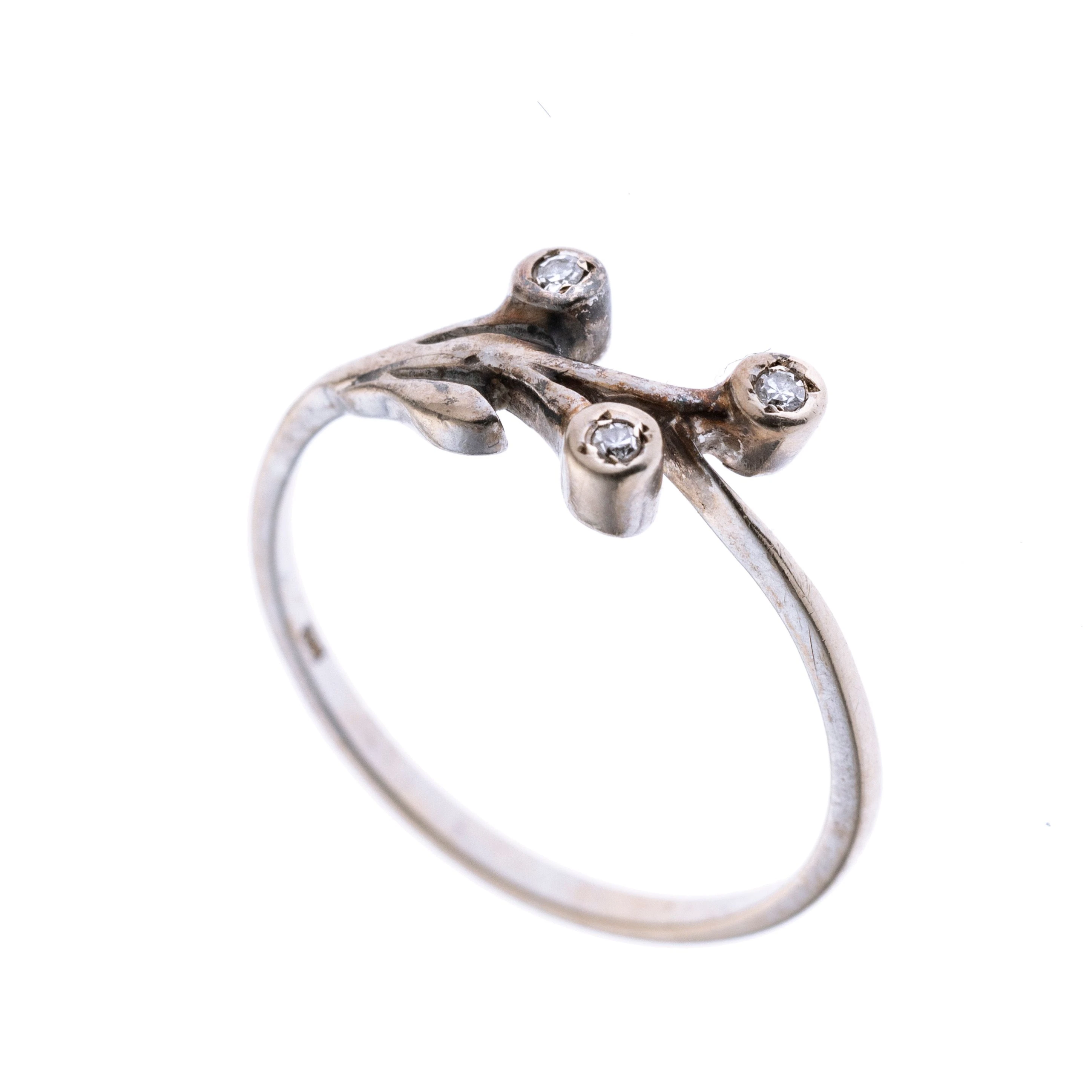 Filigraner Ring mit einem Bouquet-Design im Bereich des Ringkopfs und drei Diamanten in Zargenfassung, Blumen darstellen sollen.