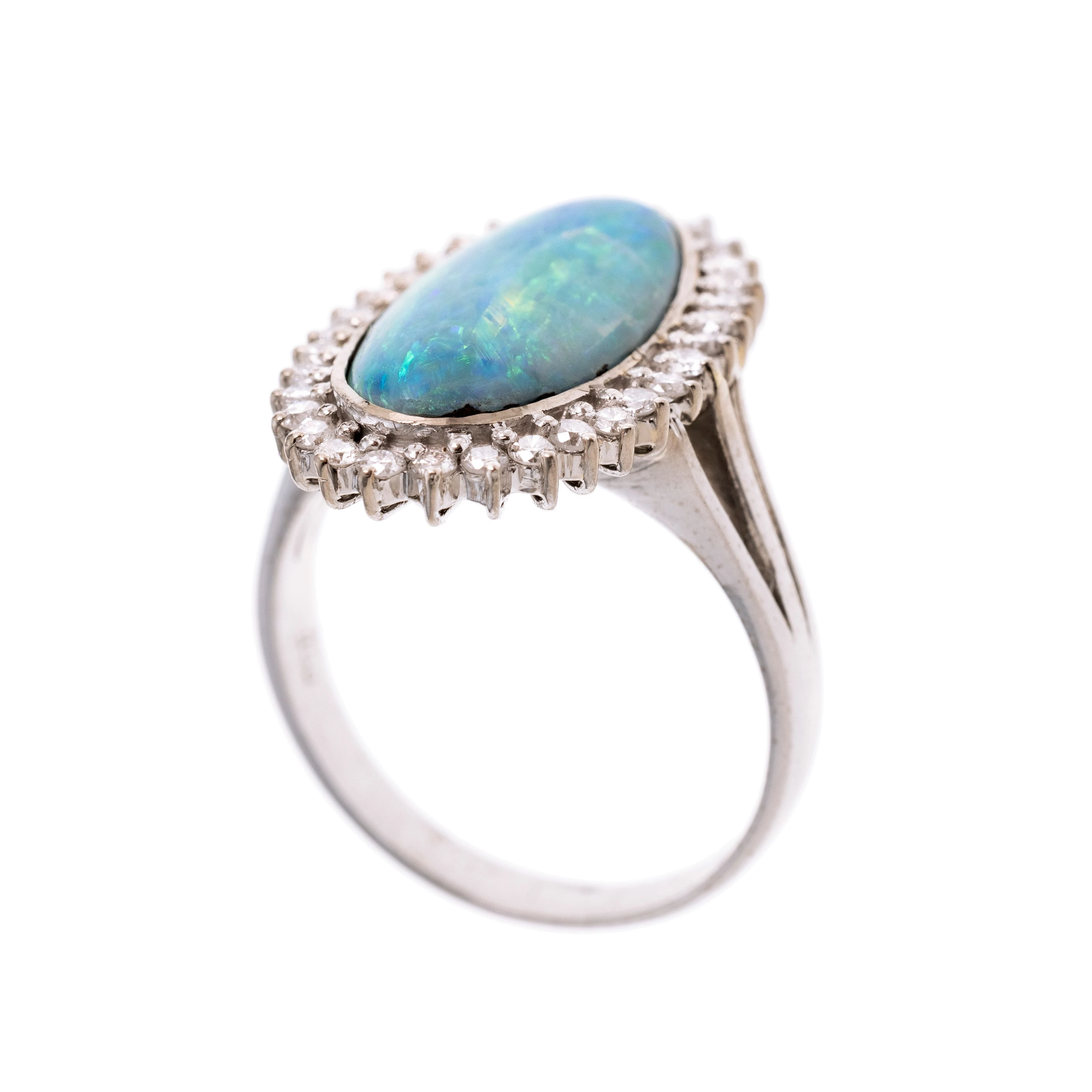Ein Opal-Cabochon der von 32 Diamanten karmoisiert wird. Die Ringschultern sind dreifach gespalten.