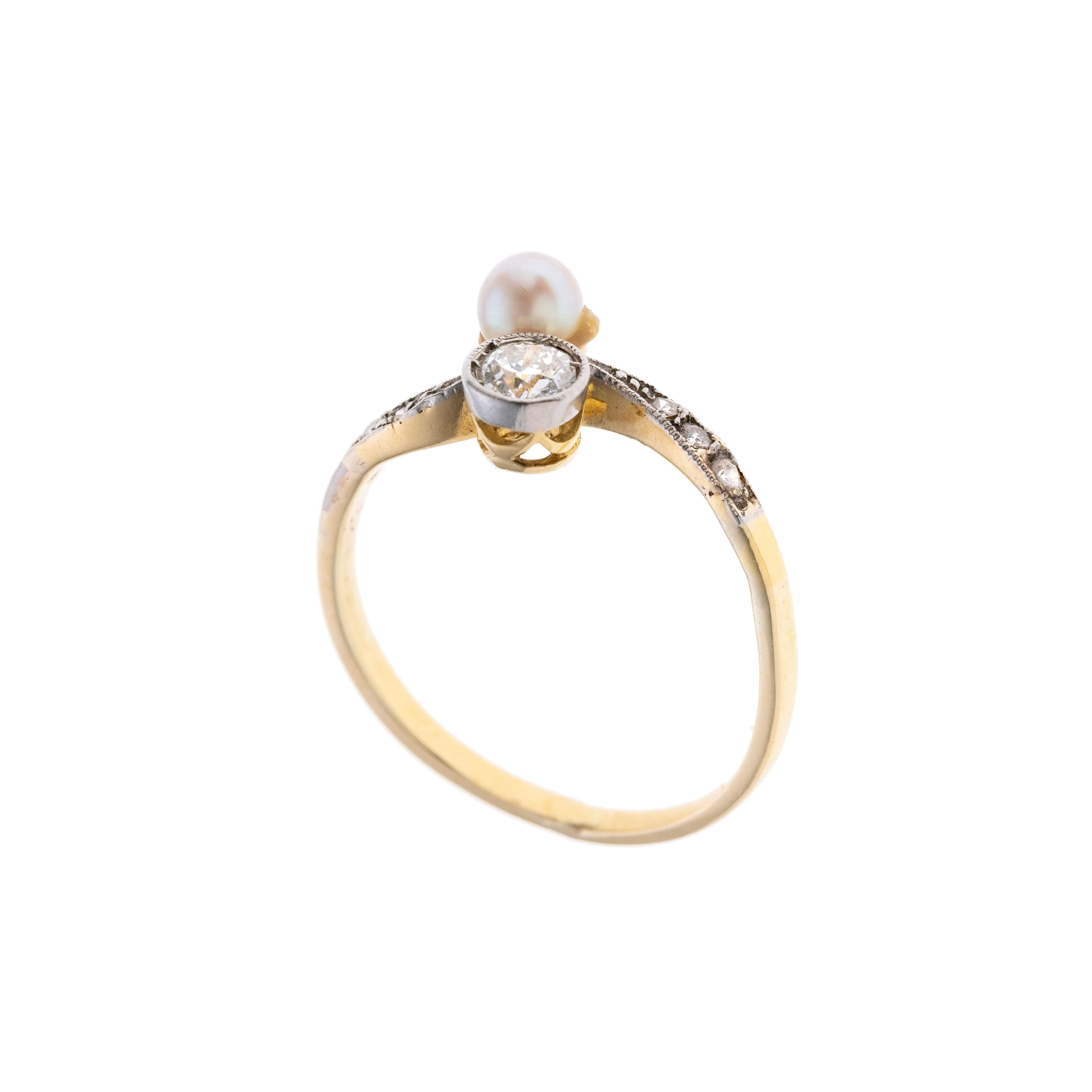 Ein Vis à Vis Ring besetzt mit einem Diamanten und einem Saphir. Die Ringschultern sind geschwungen und mit insgesamt acht Diamanten besetzt.