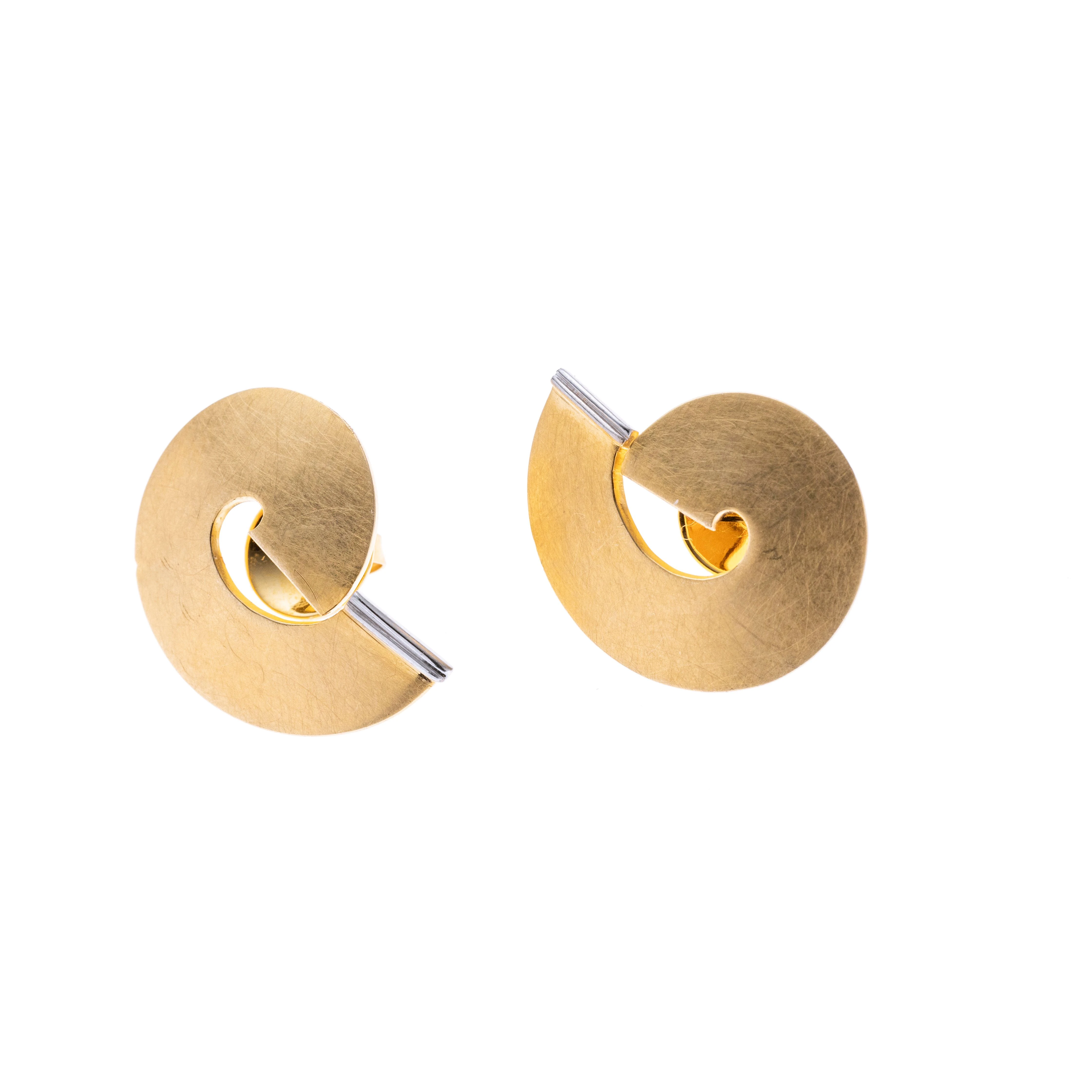 In Form einer Schnecke mit weißgoldenen Balken am Ende.